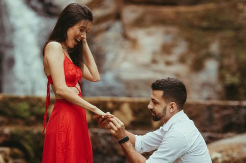 Capture of a heartfelt marriage proposal at a stunning outdoor waterfall.