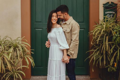 A couple shares a romantic moment outside a green door in Santa Teresa.