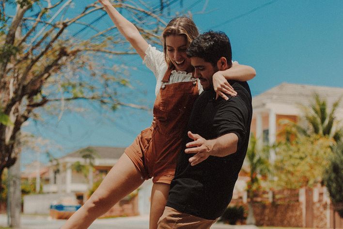 Happy couple experiencing joy and leisure while skateboarding together outdoors in Rio de Janeiro.