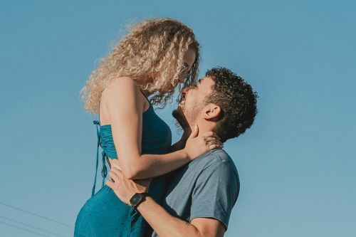 A couple in love embracing on a rural road under a clear blue sky in Presidente Prudente, Brasil.